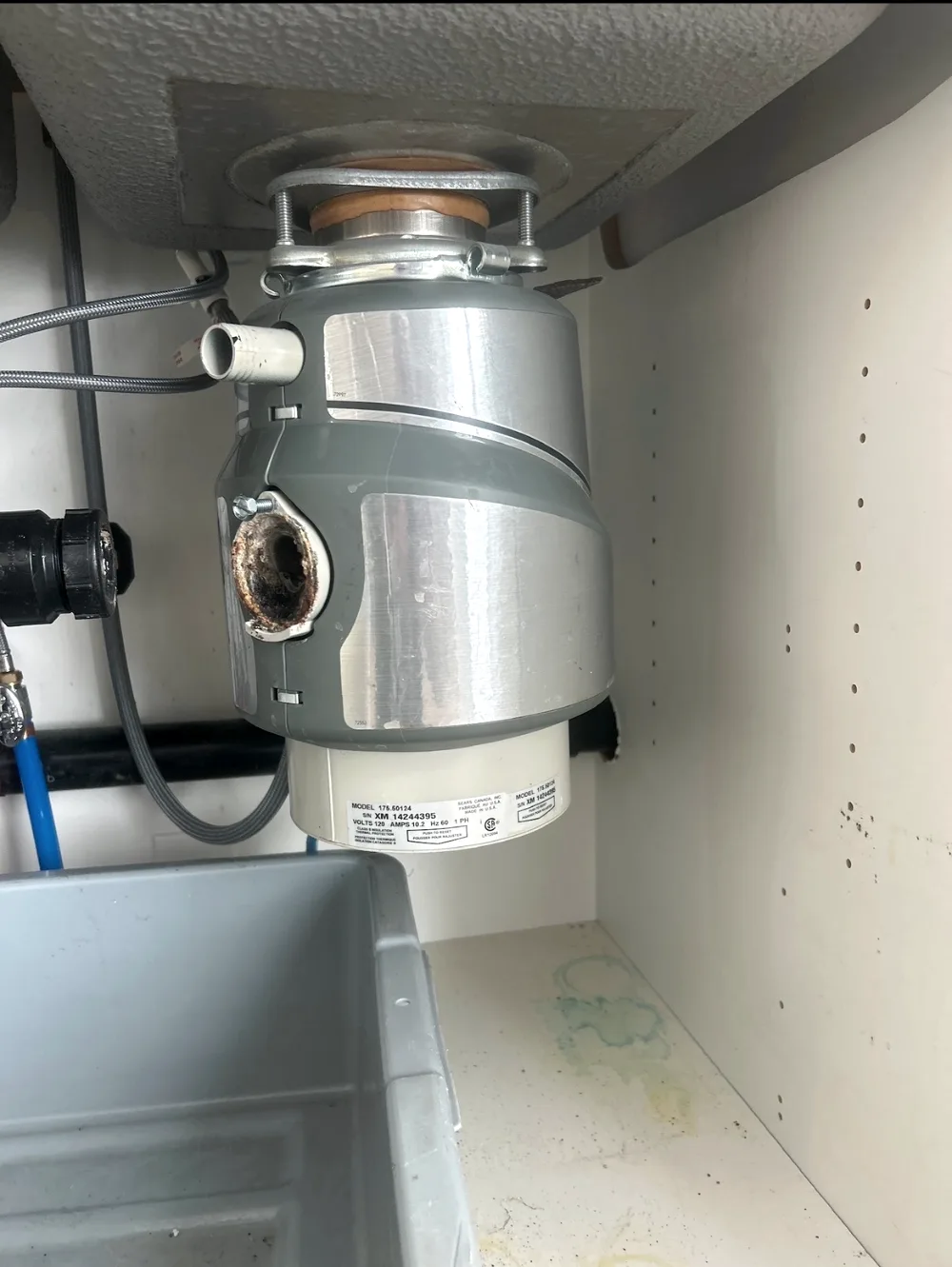 Garbage disposal and fixtures installed under a Calgary kitchen sink