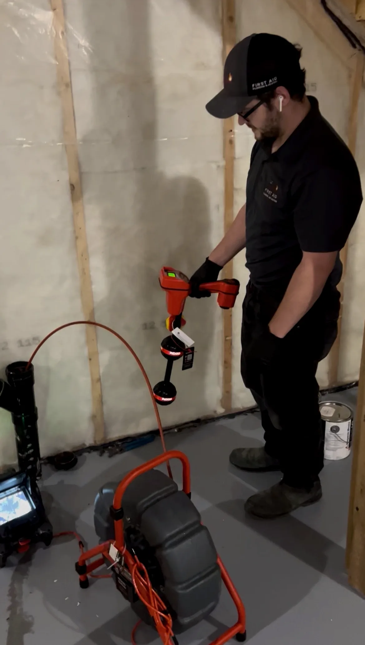 Technician running a drain inspection camera in a Calgary basement