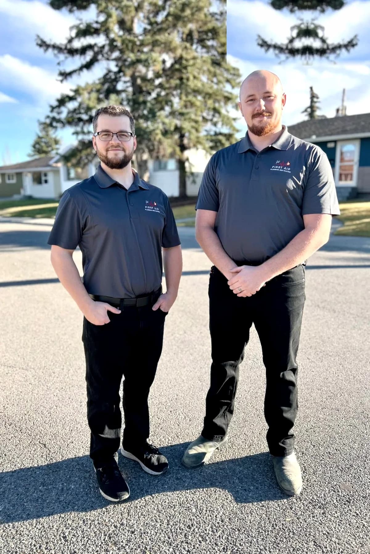 First Aid Plumbing and Heating owners Logan and Frank in branded uniforms on a Calgary street